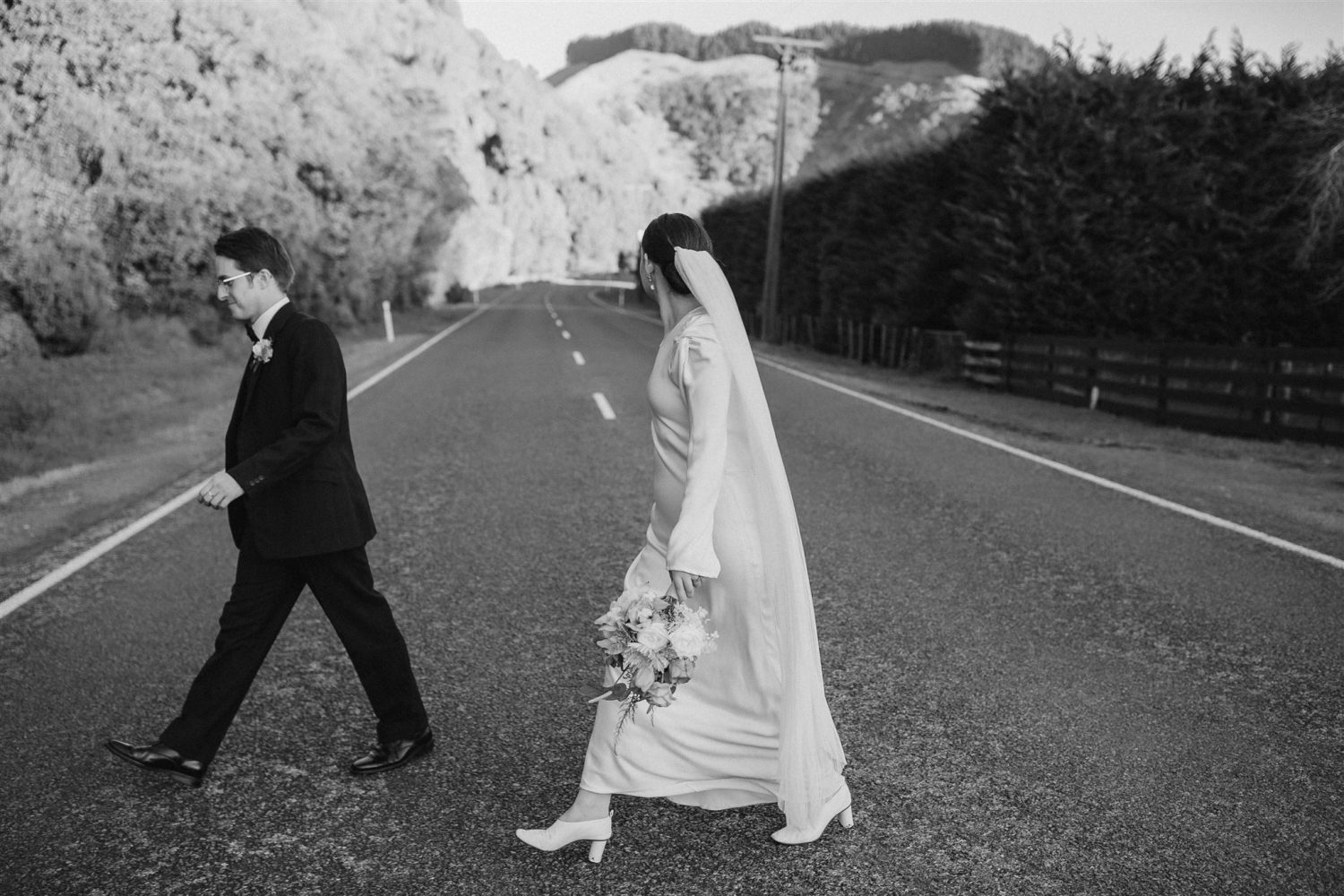 bride and groom walking along the road in Waikanae in their vintage inspired wedding