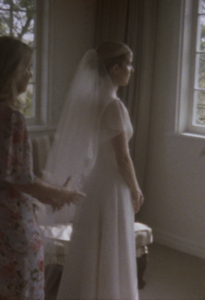Still frame from a super 8 film footage showing bride putting on veil