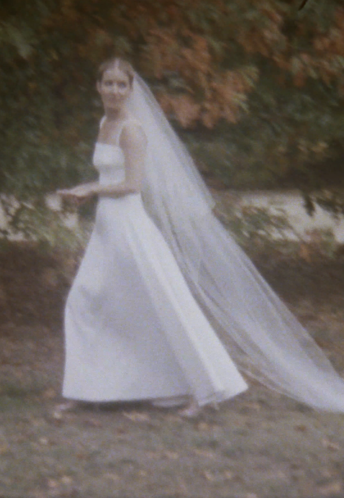 Still frame from a super 8 film footage showing a bride in her wedding dress
