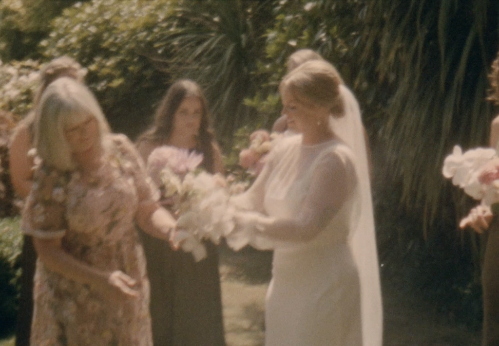 Still frame from a super 8 film footage showing bride with her mum and bridesmaids