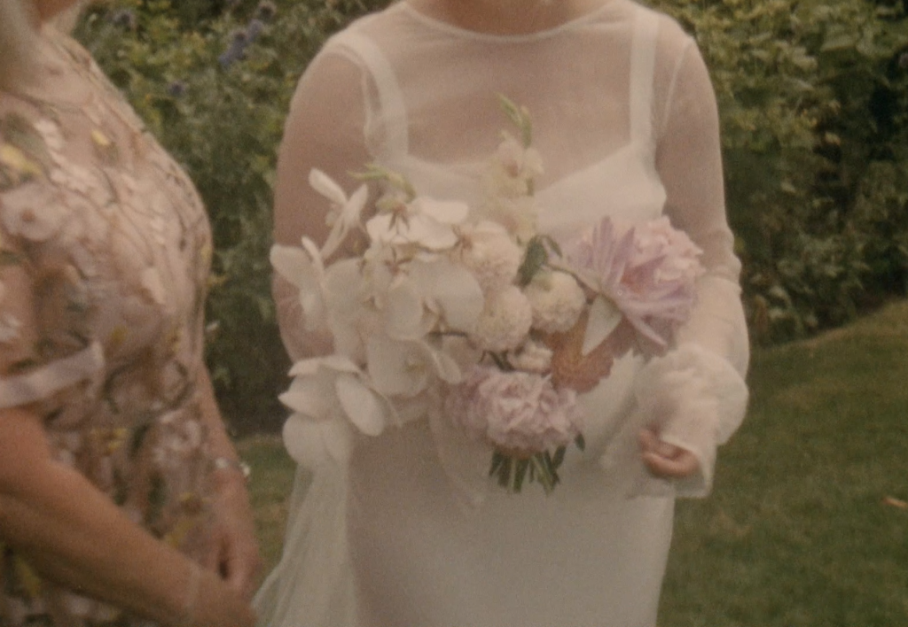 Still frame from a super 8 film footage showing bride holding wedding flowers