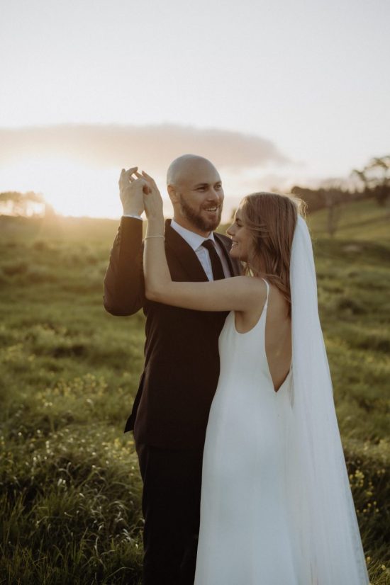 bride and groom enjoying the sun setting behind them and cold breeze passing by them Ana Galloway Photography