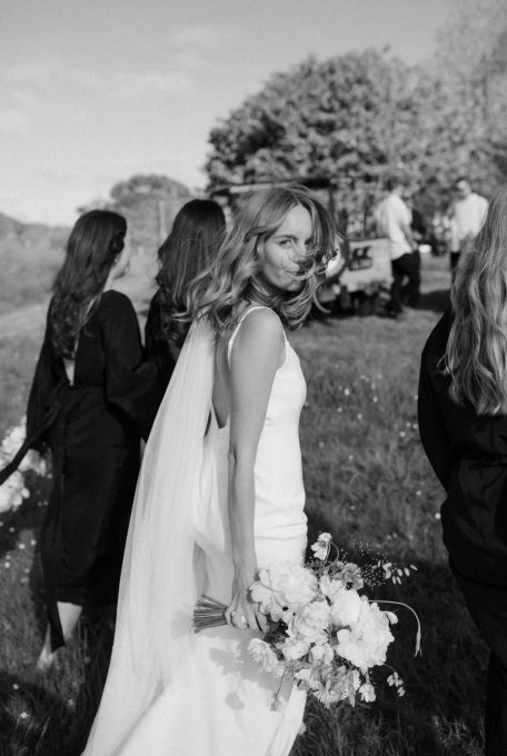 bride walking with her bridesmaids while cold breeze pass them black and white Ana Galloway Photography