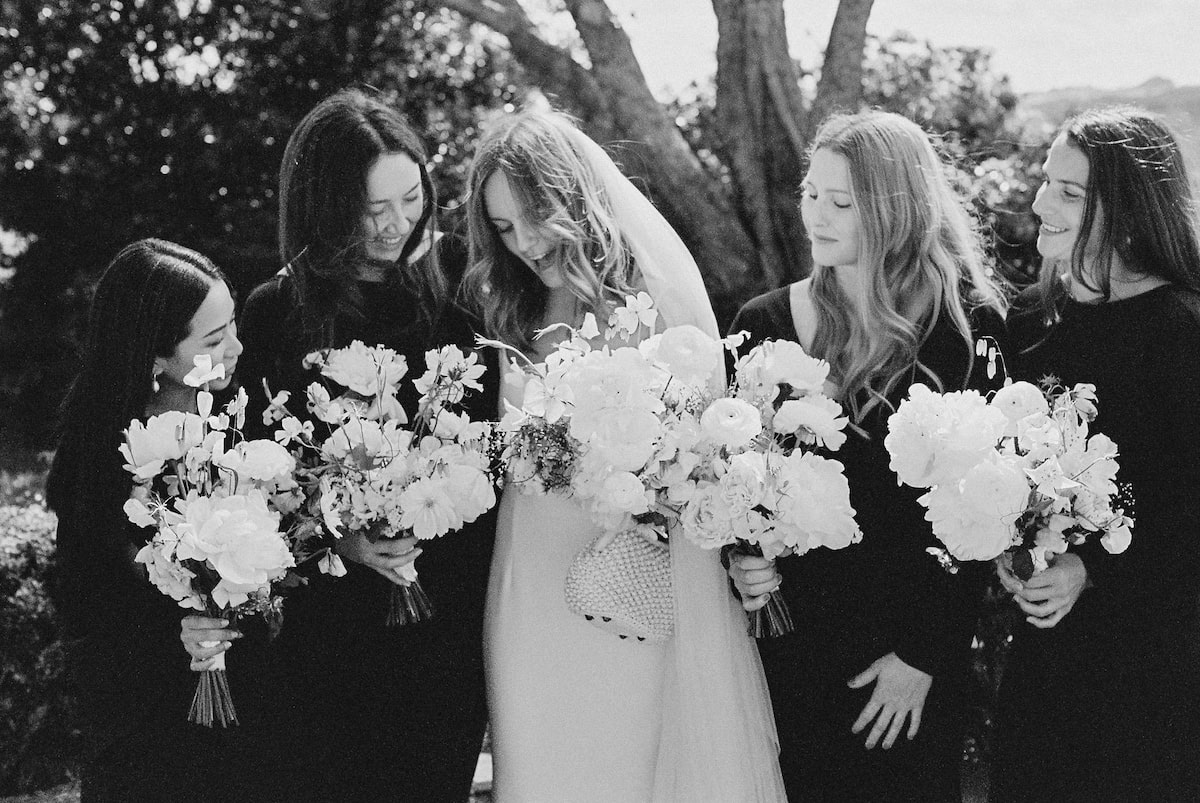 The bride and her bridesmaids sharing a sweet moment and a laugh together. Ana Galloway Photography