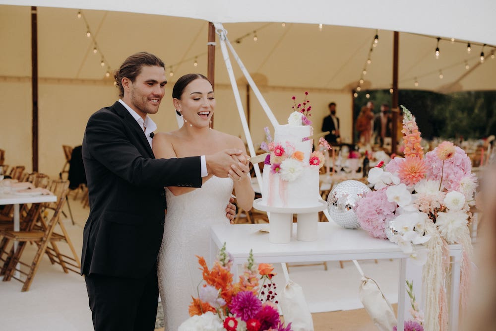 bride and groom slicing their wedding cake in their wedding ceremony