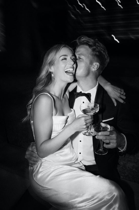 bride and groom having fun in their wedding party sharing champagne to celebrate tying the knot. Ana Galloway Photography
